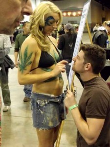 Girl with marijuana tattoos and guy at a cannabis convention