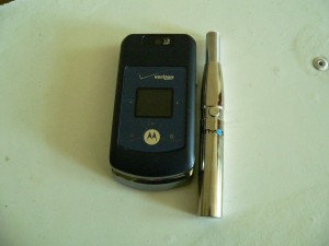 Atmos personal vaporizer pictured next to a cell phone