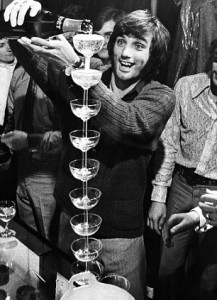 George Best pouring champagne onto staced champagne glasses