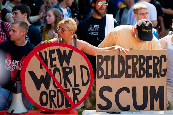 Protestors at a Bilderberg Group meeting carrying signs that say New World Order Bildereberg scum