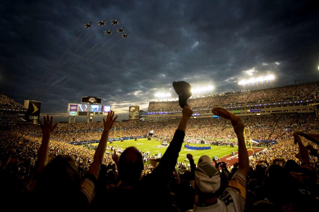 scene at an NFL game with military jets flying over the field and enthusiastic crowd