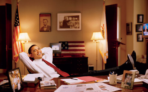 Obama relaxing in his office with pictures of Lincoln and MLK in the background