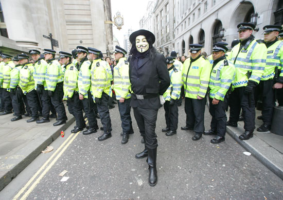 Man in V mask in front of police at G20 economic summit London